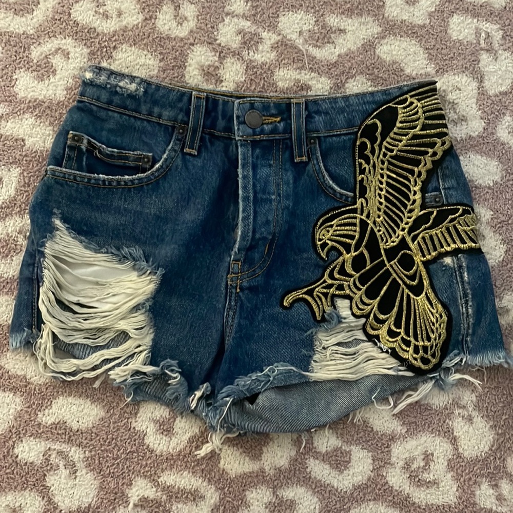 NWOT Carmar denim distressed shorts with black and gold bird detail
